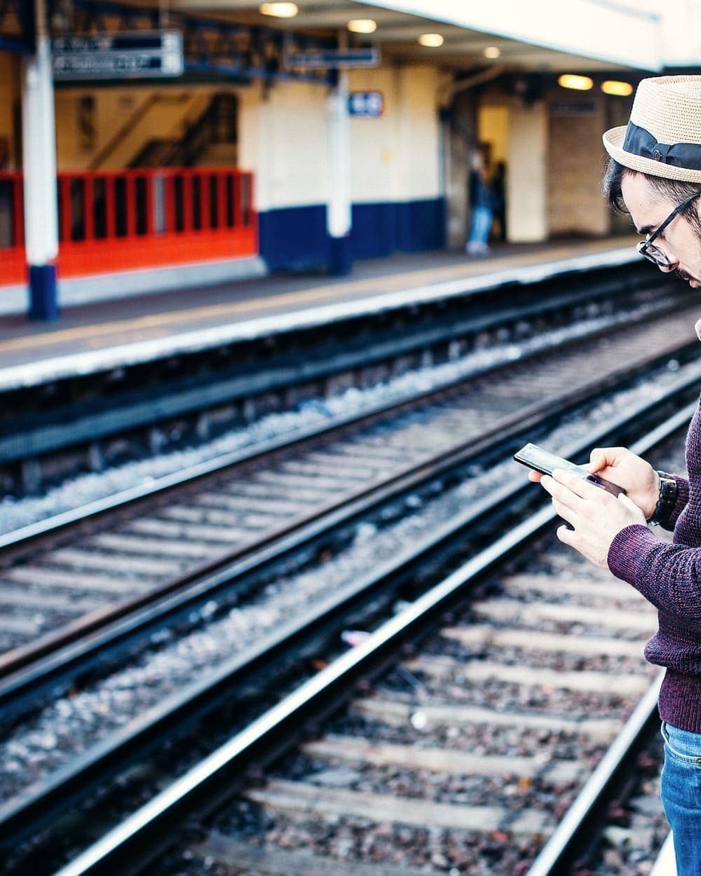 A traveller checking a phone on a railway platform