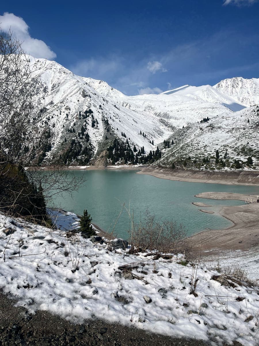 Big Almaty Lake in winter, below snow-covered mountains