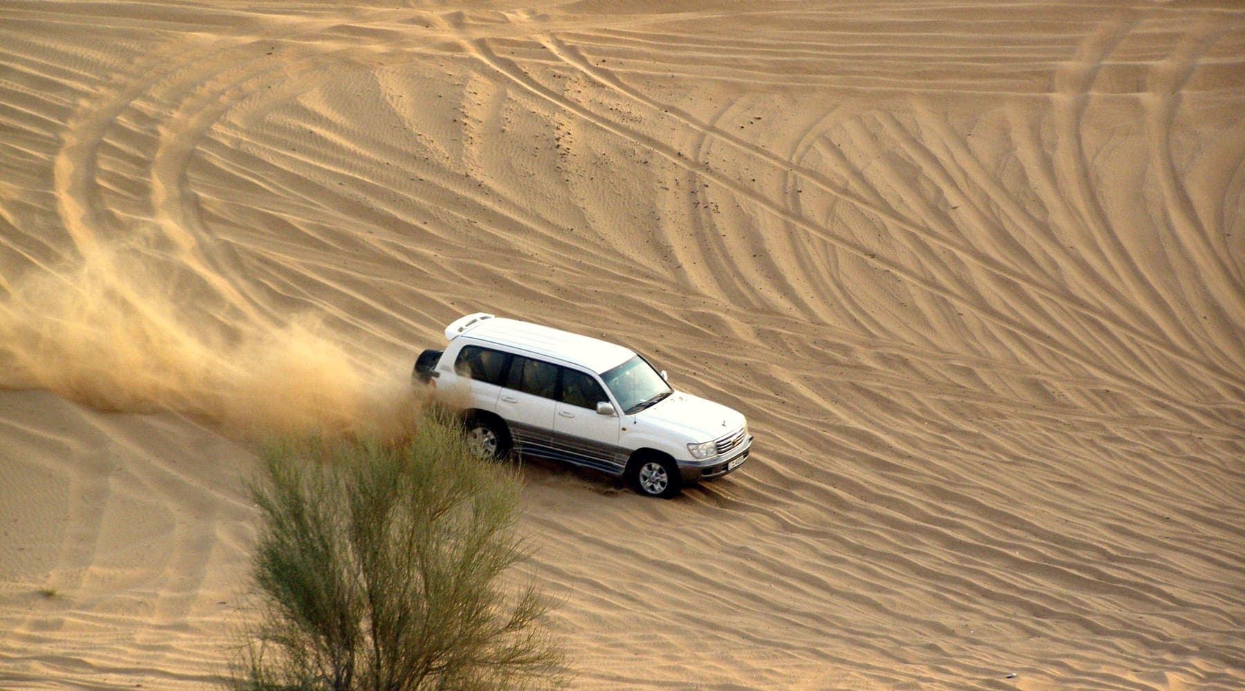 A 4x4 driving over the dunes on a Dubai desert safari