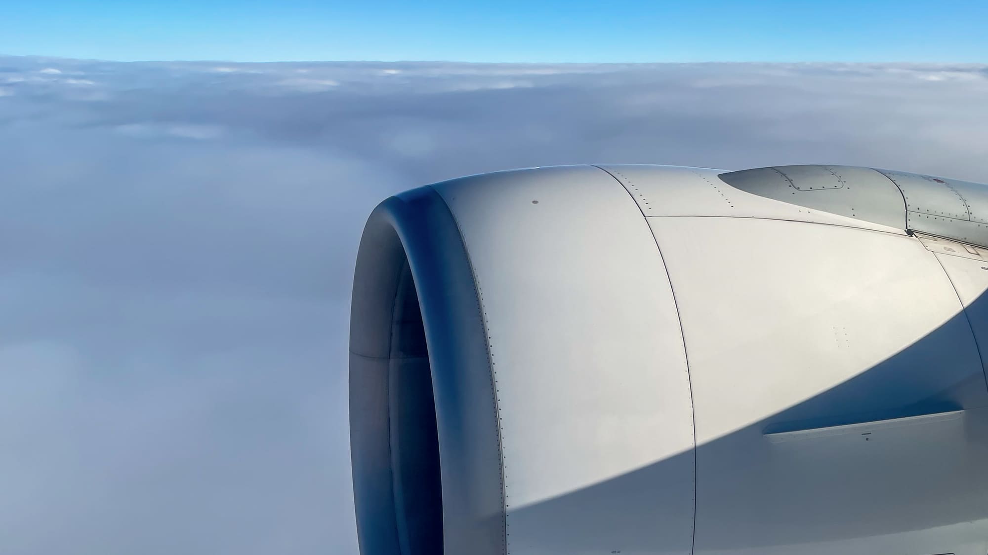An aircraft engine above the clouds, seen from the cabin window