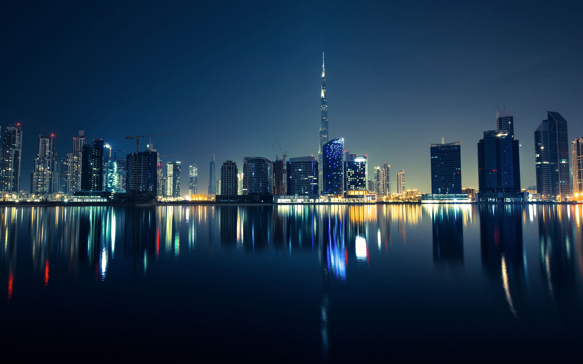 The Dubai skyline reflected in the water at night